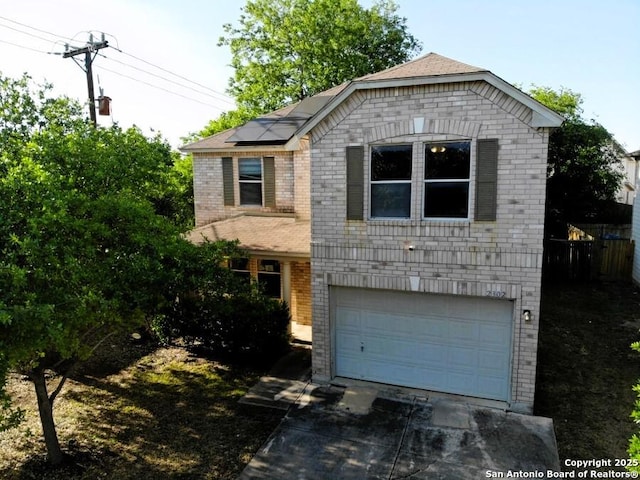 view of front of home with an attached garage, solar panels, driveway, and brick siding