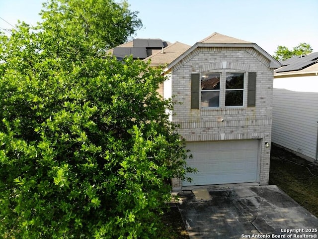 view of side of property with driveway, a garage, and brick siding