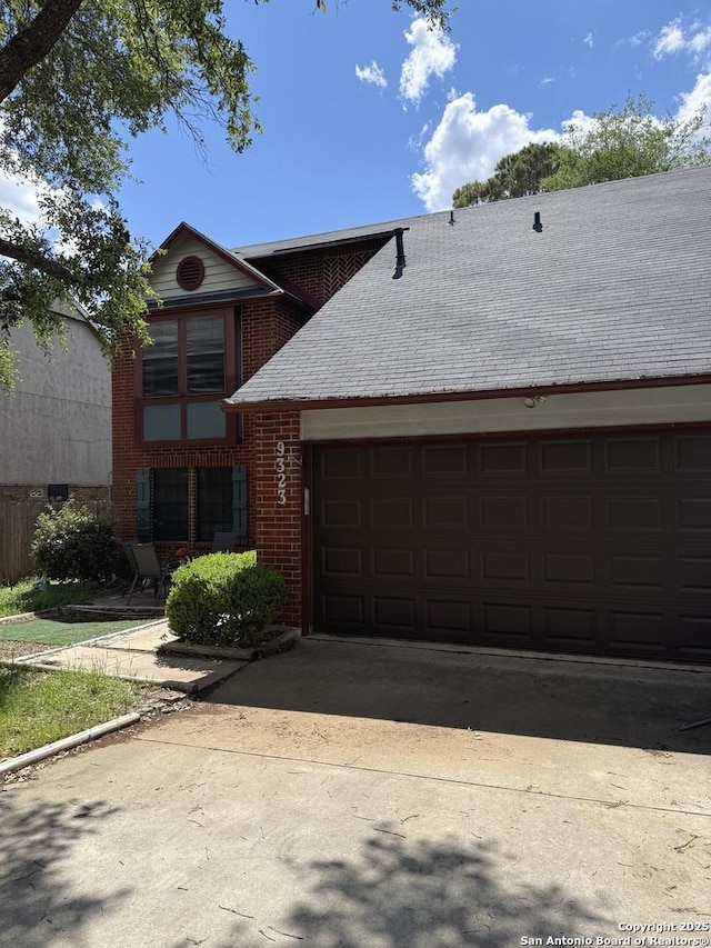 9323 Andersonville, San Antonio, TX 78240 - view of front facade with brick siding, an attached garage, concrete driveway, and a shingled roof