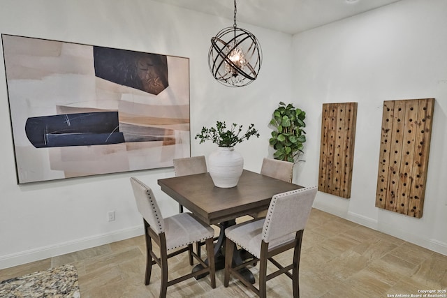 dining room featuring a chandelier and baseboards