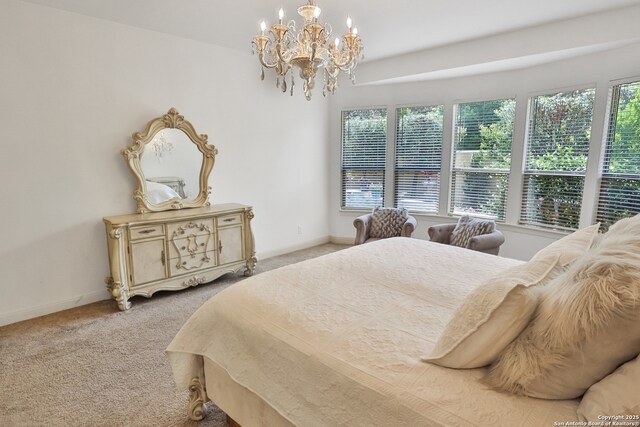 bedroom featuring a chandelier, light colored carpet, and baseboards