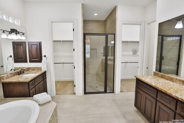 bathroom with a shower stall, vanity, tile patterned flooring, recessed lighting, and baseboards