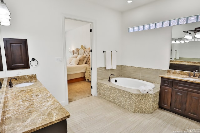 ensuite bathroom with two vanities, a garden tub, recessed lighting, and tile patterned floors