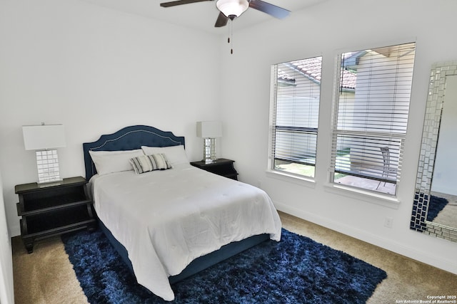 carpeted bedroom featuring baseboards and a ceiling fan