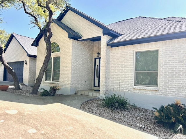 552 Mountain Oaks, Canyon Lake, TX 78133 - view of front of property featuring brick siding, an attached garage, and roof with shingles