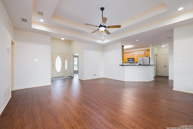 552 Mountain Oaks, Canyon Lake, TX 78133 - unfurnished living room featuring a tray ceiling, recessed lighting, ceiling fan, crown molding, and dark wood-style floors