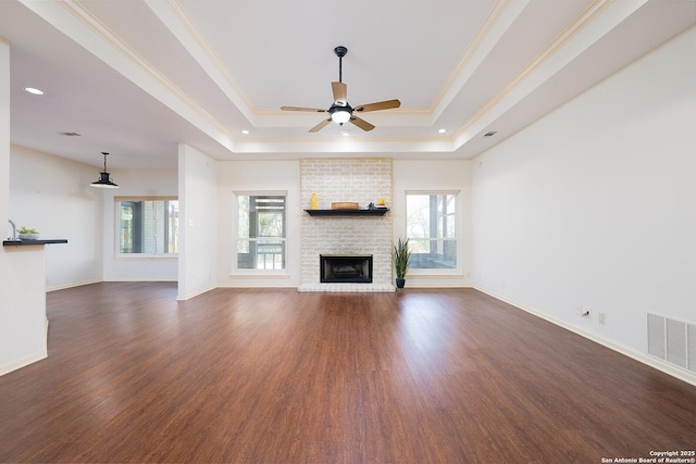 552 Mountain Oaks, Canyon Lake, TX 78133 - unfurnished living room featuring a tray ceiling, healthy amount of natural light, a fireplace, ceiling fan, and ornamental molding