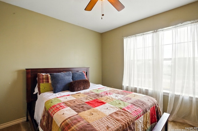 carpeted bedroom with ceiling fan and baseboards