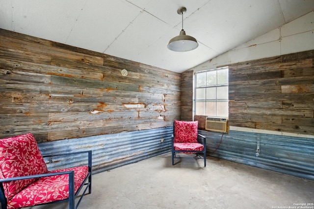 living area featuring wooden walls, unfinished concrete flooring, and lofted ceiling