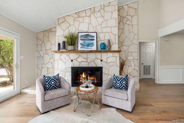 3010 Skyline, Canyon Lake, TX 78133 - living area with lofted ceiling, a fireplace, wood finished floors, and a wainscoted wall