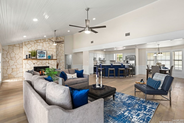 3010 Skyline, Canyon Lake, TX 78133 - living room with light wood-style flooring, a ceiling fan, a stone fireplace, recessed lighting, and a wainscoted wall