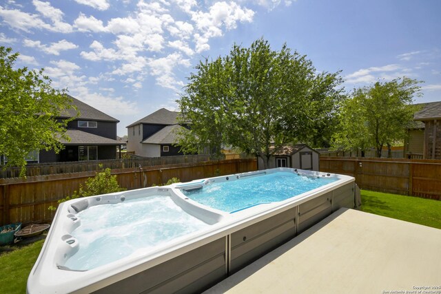 1710 Briar Spg, San Antonio, TX 78245 - view of pool with an outdoor hot tub, a fenced backyard, a storage unit, and an outdoor structure