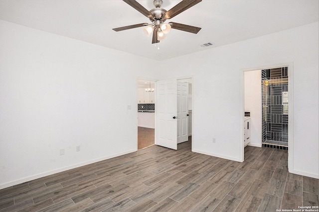 1615 N Guadalupe, Seguin, TX 78155 - unfurnished bedroom with wood finished floors, baseboards, a walk in closet, and a chandelier