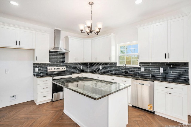 1615 N Guadalupe, Seguin, TX 78155 - kitchen featuring appliances with stainless steel finishes, a sink, wall chimney exhaust hood, white cabinetry, and a chandelier