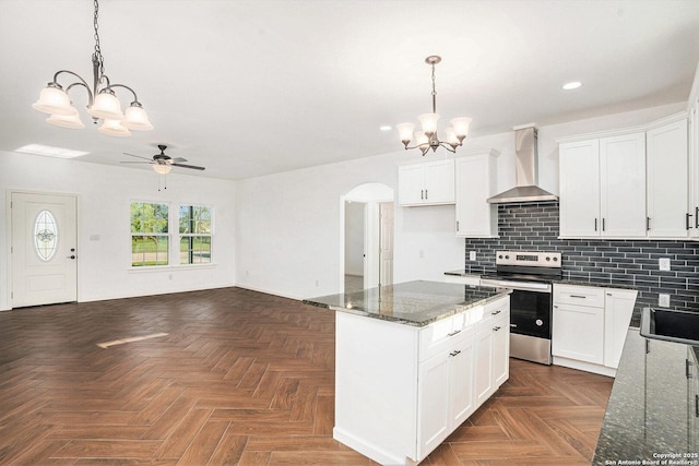 1615 N Guadalupe, Seguin, TX 78155 - kitchen with wall chimney range hood, stainless steel electric stove, a chandelier, recessed lighting, and arched walkways