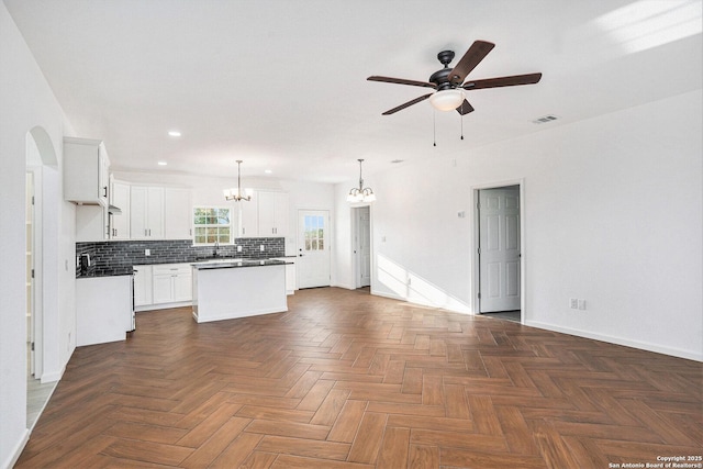 1615 N Guadalupe, Seguin, TX 78155 - kitchen featuring a chandelier, a ceiling fan, a center island, backsplash, and baseboards