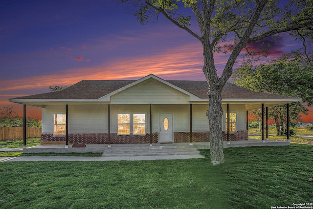 1615 N Guadalupe, Seguin, TX 78155 - back of house at dusk featuring covered porch, brick siding, and roof with shingles