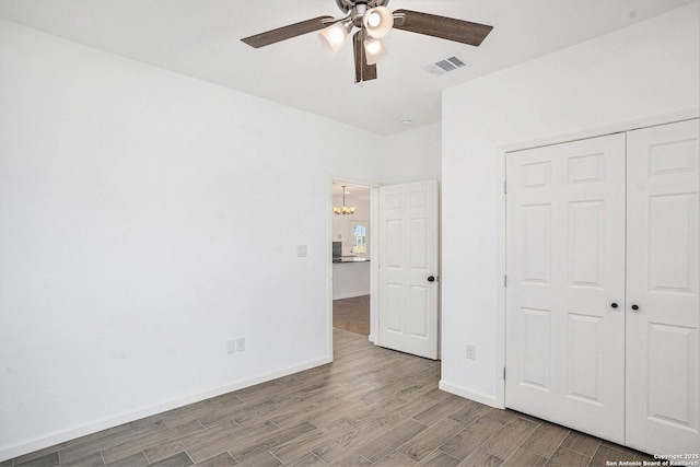 1615 N Guadalupe, Seguin, TX 78155 - unfurnished bedroom featuring wood finished floors, a chandelier, a closet, baseboards, and ceiling fan