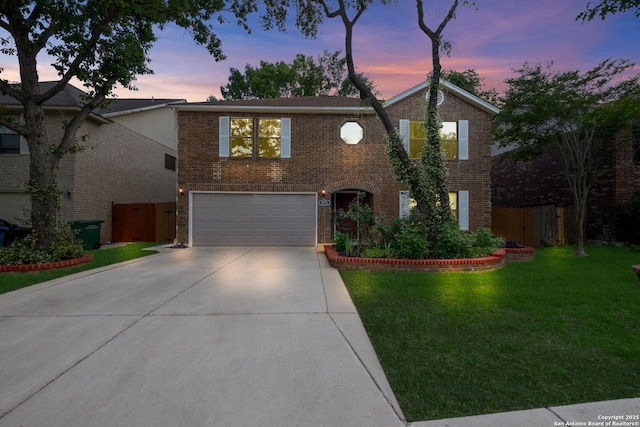 traditional-style home featuring an attached garage, driveway, and brick siding