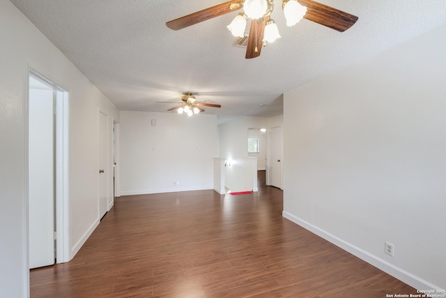empty room featuring a ceiling fan, dark wood-type flooring, a textured ceiling, and baseboards