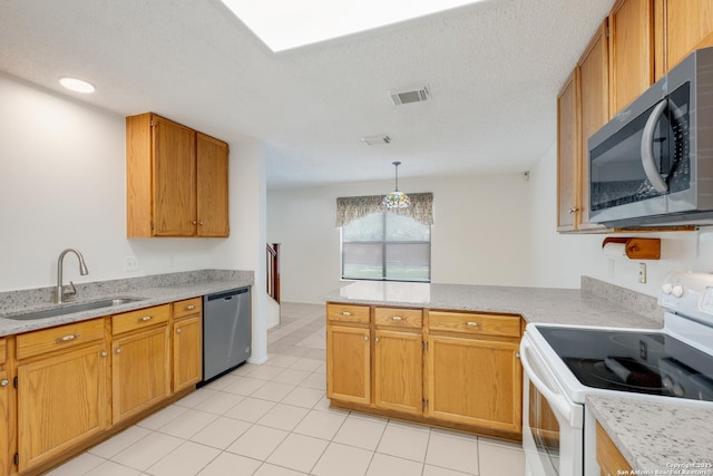 kitchen with appliances with stainless steel finishes, a sink, a peninsula, light tile patterned floors, and pendant lighting