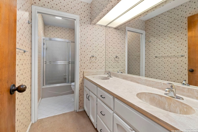 11421 Mission Trce, San Antonio, TX 78230 - bathroom featuring double vanity, tile patterned flooring, toilet, wallpapered walls, and bath / shower combo with glass door