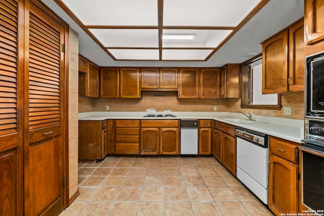 11421 Mission Trce, San Antonio, TX 78230 - kitchen featuring white dishwasher, a sink, brown cabinetry, light countertops, and oven
