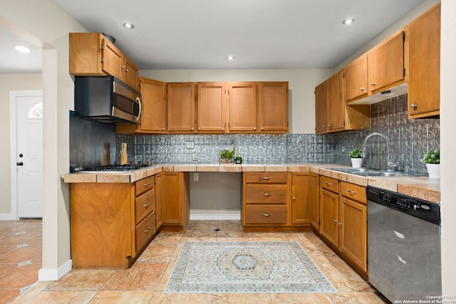 kitchen with stainless steel appliances, a sink, decorative backsplash, brown cabinetry, and recessed lighting