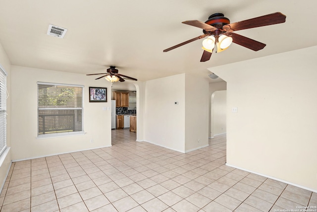 3601 Diamond Fls, Schertz, TX 78154 - empty room with arched walkways, ceiling fan, light tile patterned floors, and baseboards