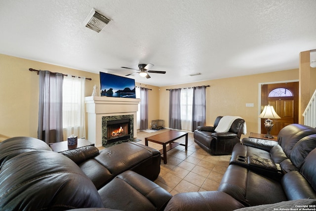 934 Saxonhill, San Antonio, TX 78253 - living room with plenty of natural light, a textured ceiling, light tile patterned flooring, ceiling fan, and a high end fireplace