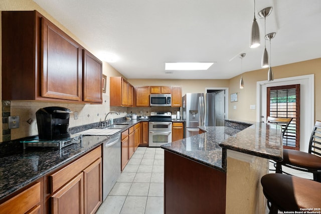 934 Saxonhill, San Antonio, TX 78253 - kitchen featuring stainless steel appliances, a sink, a breakfast bar area, decorative backsplash, and hanging light fixtures