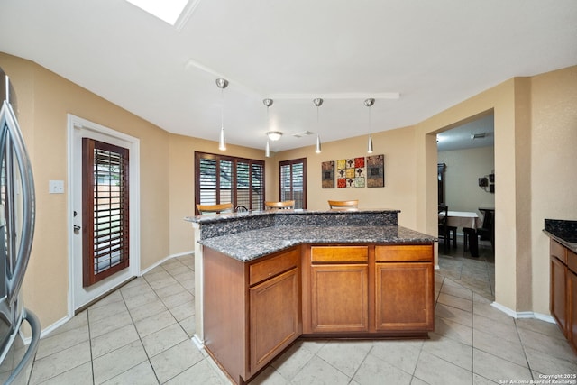 934 Saxonhill, San Antonio, TX 78253 - kitchen featuring stainless steel fridge, light tile patterned flooring, baseboards, brown cabinets, and dark stone countertops