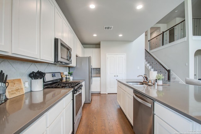 7606 Cottonwood Fls, Spring, TX 77379 - kitchen featuring stainless steel appliances, a sink, dark wood finished floors, white cabinets, and recessed lighting