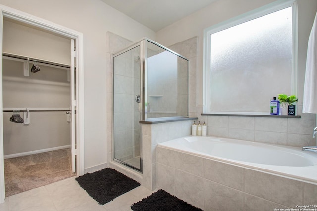 7606 Cottonwood Fls, Spring, TX 77379 - full bathroom featuring a shower stall, a spacious closet, a bath, and tile patterned flooring