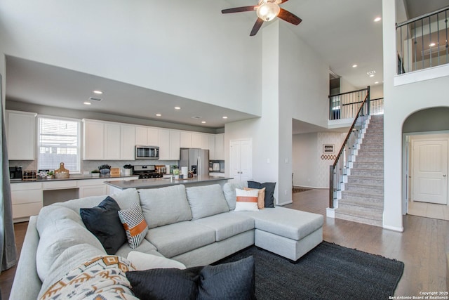 7606 Cottonwood Fls, Spring, TX 77379 - living room featuring wood finished floors, a ceiling fan, stairway, a towering ceiling, and recessed lighting