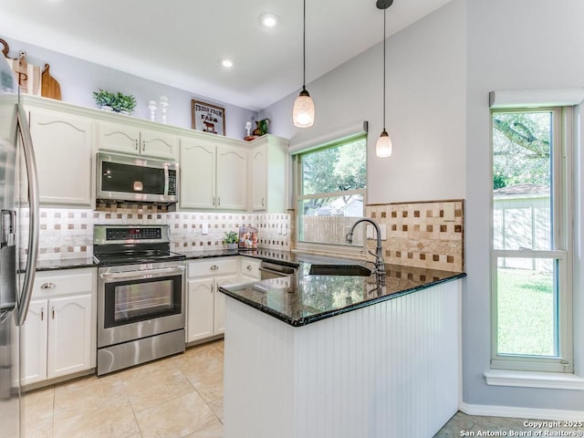 kitchen featuring stainless steel appliances, a sink, a peninsula, white cabinets, and recessed lighting