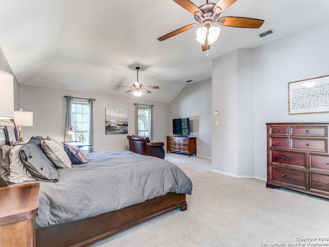 bedroom with light colored carpet, vaulted ceiling, baseboards, and a ceiling fan