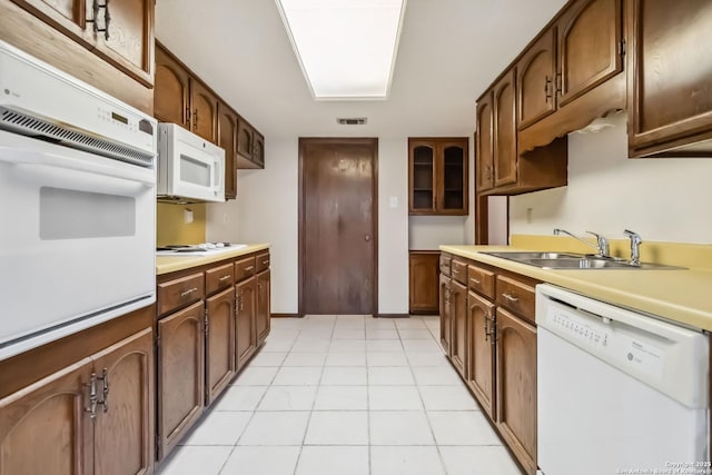 10514 Merritime Ct, San Antonio, TX 78217 - kitchen featuring white appliances, a sink, light countertops, light tile patterned flooring, and glass insert cabinets