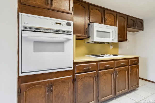 10514 Merritime Ct, San Antonio, TX 78217 - kitchen with white appliances, light countertops, light tile patterned flooring, and baseboards
