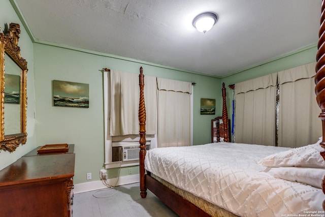 bedroom with wood finished floors, cooling unit, and baseboards