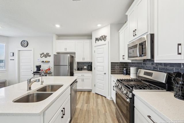 306 Banff, Kyle, TX 78640 - kitchen featuring appliances with stainless steel finishes, a sink, an island with sink, recessed lighting, and light wood-style floors