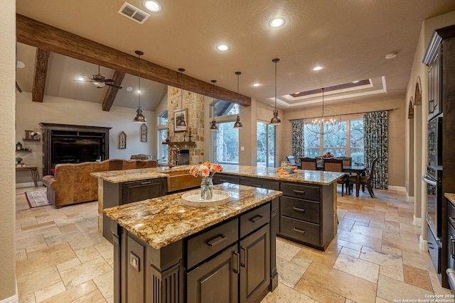 1040 Glenwood, Bulverde, TX 78163 - kitchen featuring an island with sink, a stone fireplace, open floor plan, stone tile flooring, and recessed lighting