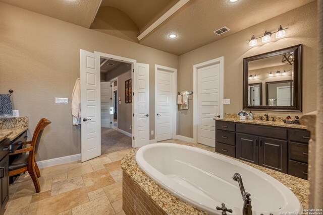 1040 Glenwood, Bulverde, TX 78163 - full bathroom with a bath, baseboards, vanity, stone tile floors, and lofted ceiling