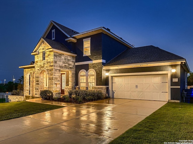 view of front of property featuring stone siding, driveway, an attached garage, a front lawn, and stucco siding
