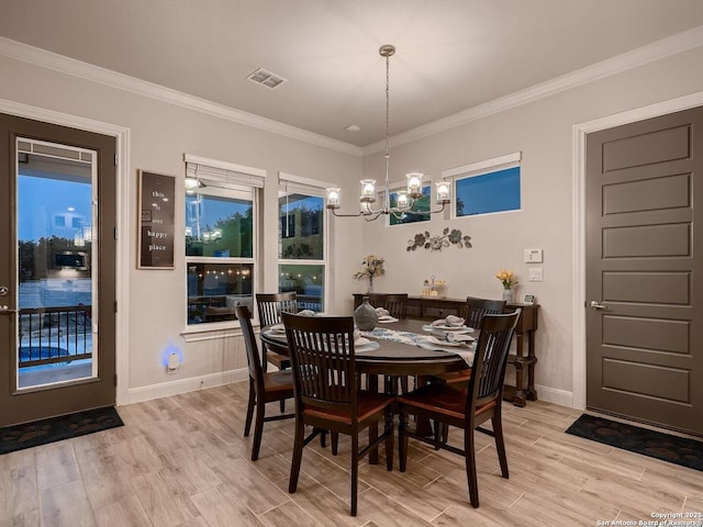 dining space with a chandelier, baseboards, light wood finished floors, and crown molding