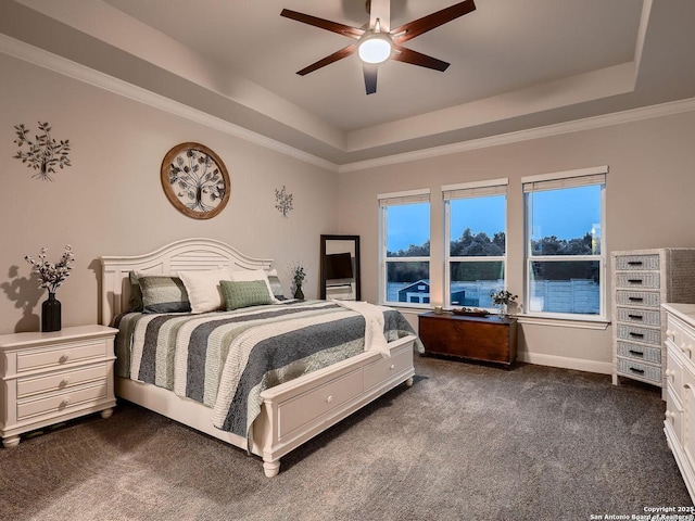bedroom featuring a raised ceiling, dark colored carpet, ceiling fan, and baseboards