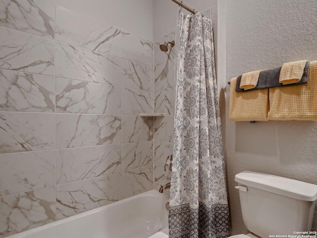 bathroom featuring shower / tub combo and toilet