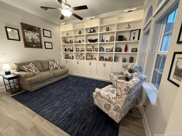 living area with crown molding and ceiling fan
