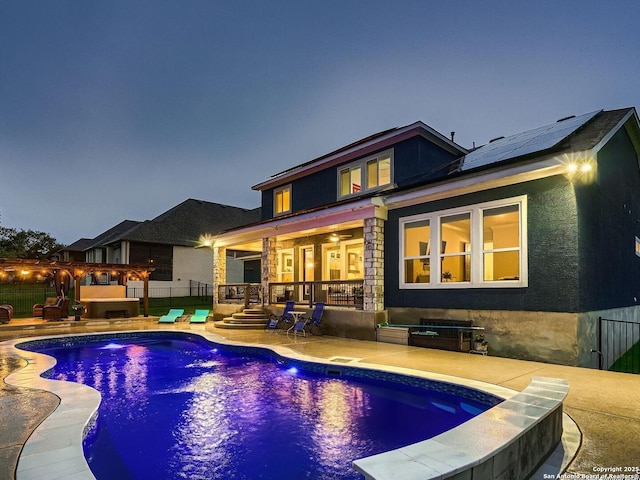 back of house featuring a patio, solar panels, a ceiling fan, fence, and stucco siding