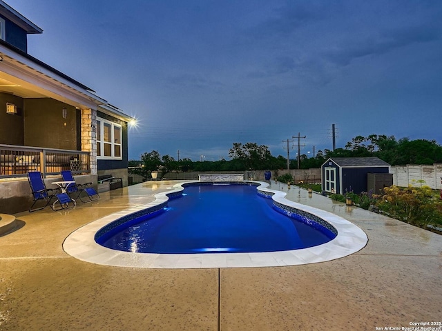view of swimming pool featuring a patio, a shed, an outdoor structure, and fence